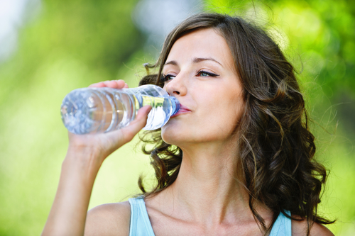 woman drinking water to follow her Wheaton skincare resolutions for healthy skin